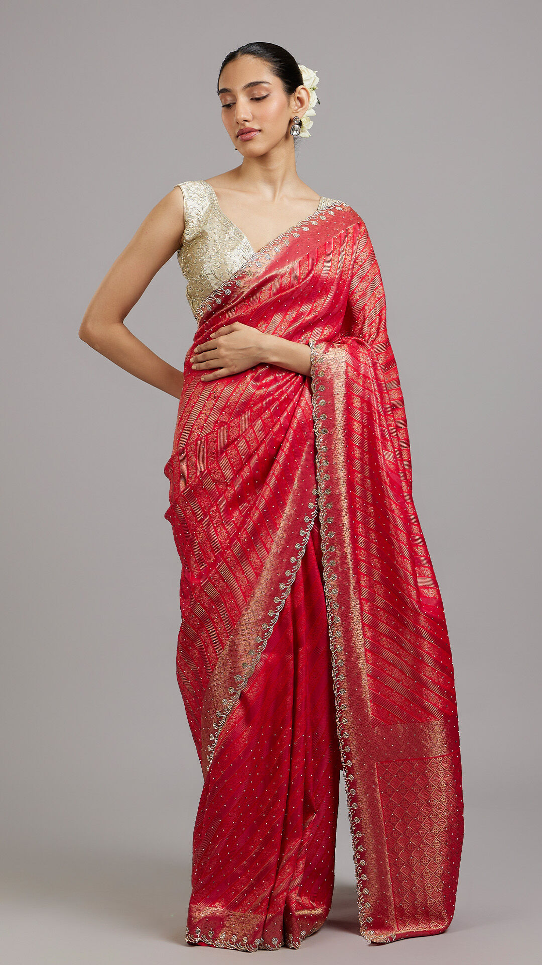 A woman wearing a red silk saree with embroidered blouse